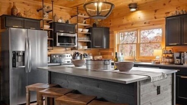 A modern kitchen with a large island, stainless steel appliances, wooden cabinets, and a farmhouse aesthetic. - 🍃Serendipity Lodge🌲Mountain Views, Theater, Game Room & Pet-Friendly (Sevierville)