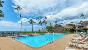 A swimming pool with lounge chairs and a view of the ocean. - Ma'alaea Surf #G-2 – Relaxing Ground-Floor Getaway (Kihei, Maui)