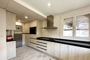 Une cuisine moderne avec un lambris en bois, un four encastré et une fenêtre offrant une belle vue.