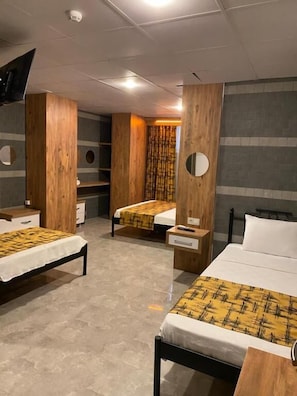 A hotel room with three beds, wooden paneling, and a modern design. - M-ODA OTEL (Antalya)