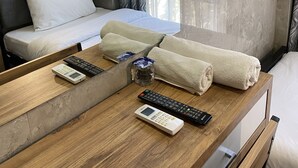 A hotel room with a wooden desk, a bed with white linens, a TV mounted on the wall, and a window with curtains. - M-ODA OTEL (Antalya)