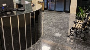 A reception area with a curved black counter, a computer, and a plant. - M-ODA OTEL (Antalya)