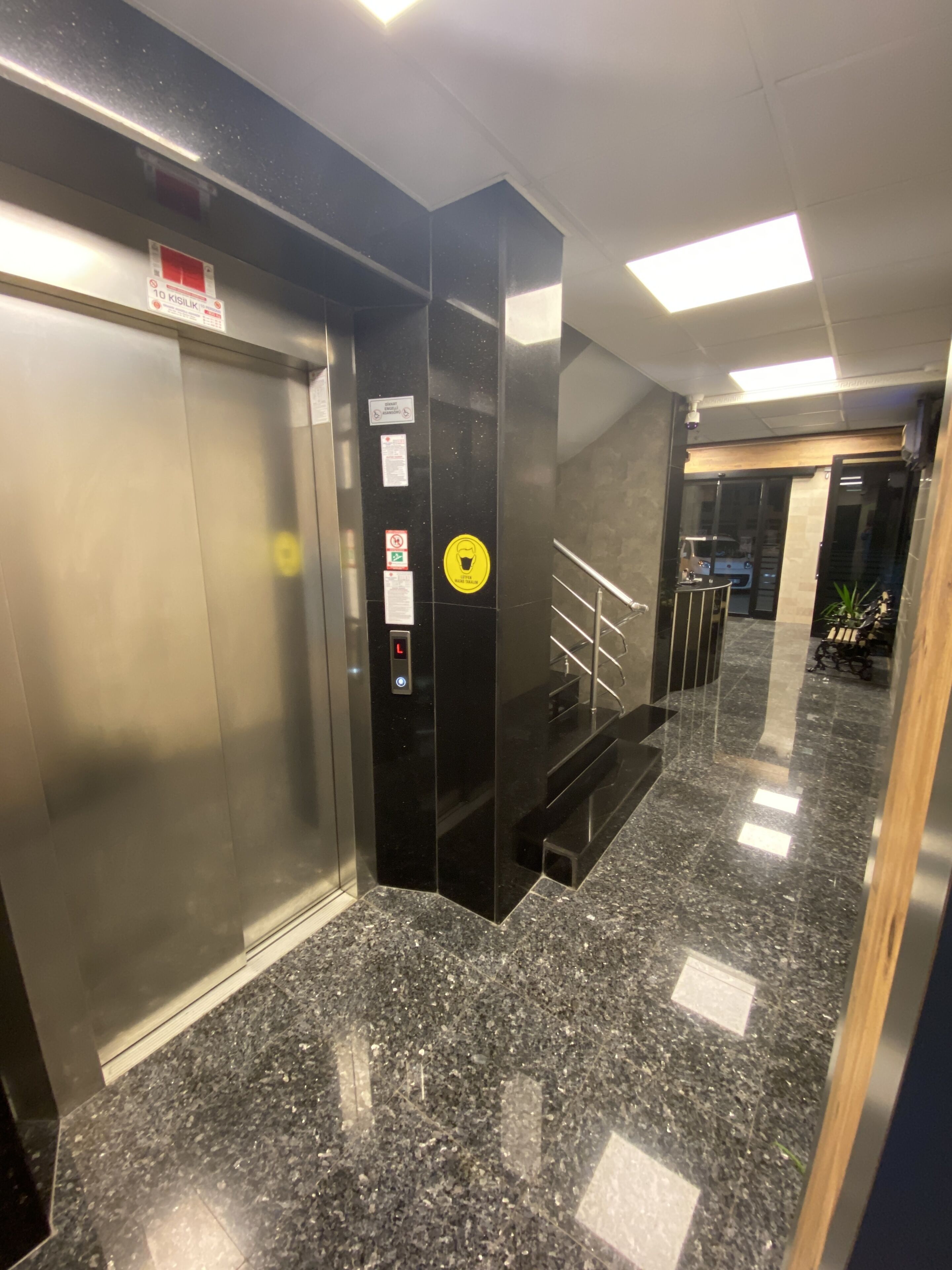 An elevator with a control panel and a sign indicating a 10-minute wait.