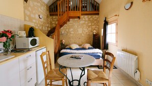 A compact kitchen with a dining table, chairs, a microwave, and a coffee maker. - Le Logis de Poëllier (Baugé-en-Anjou)