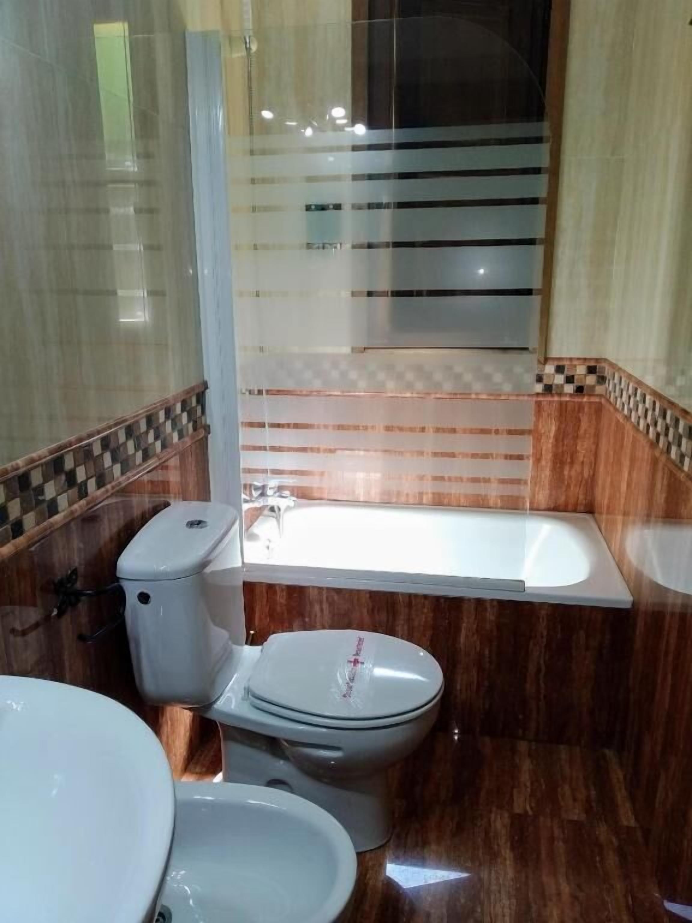 A bathroom with a toilet, sink, and bathtub.