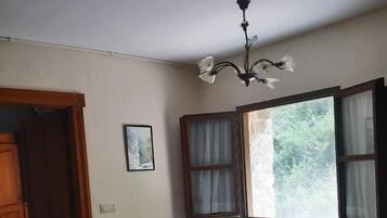 Un espacio habitable pequeño con kitchenette, un banco y una mesa.