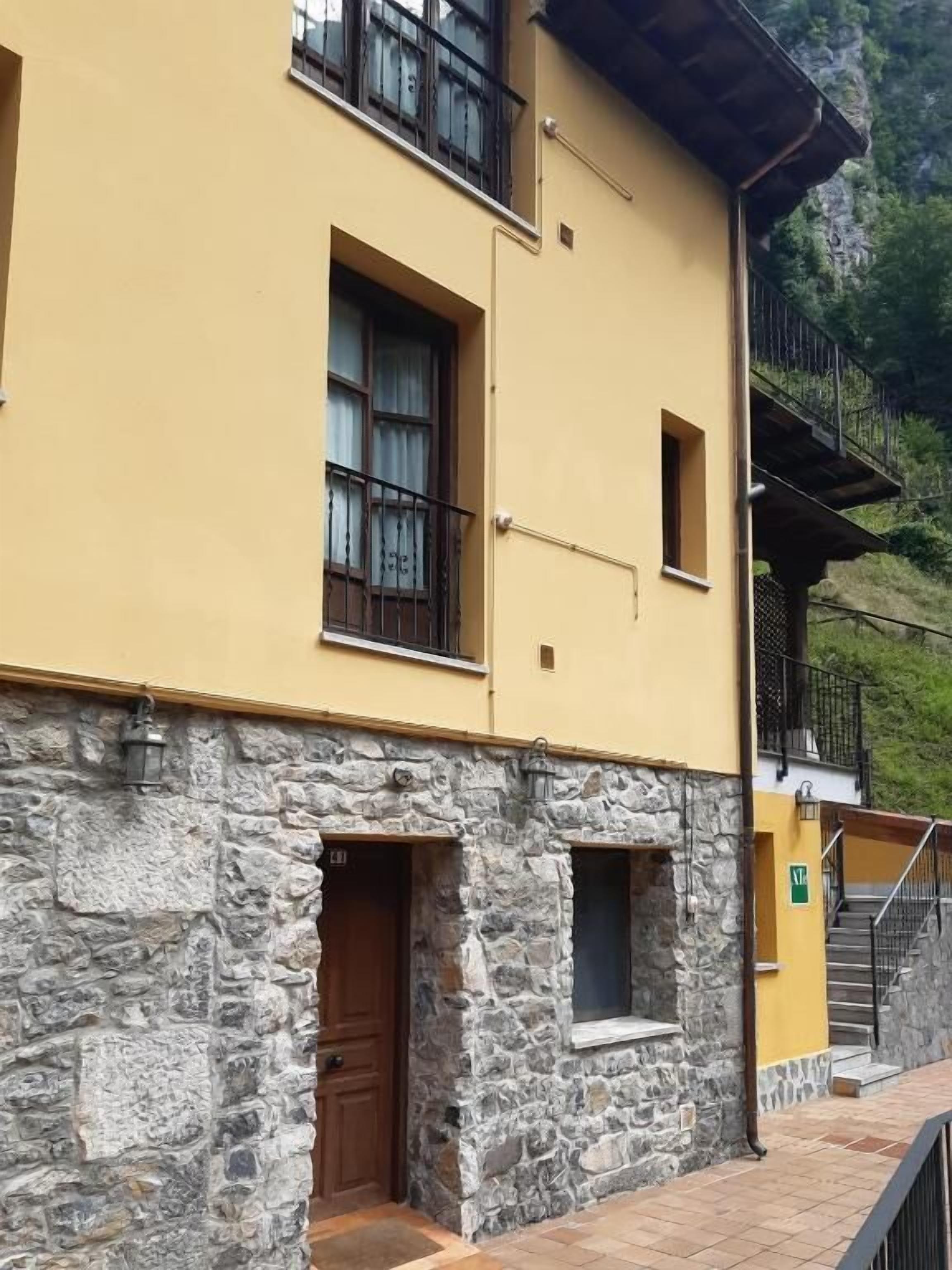 Un bâtiment à deux étages, doté d’une façade en pierre et de murs jaunes.