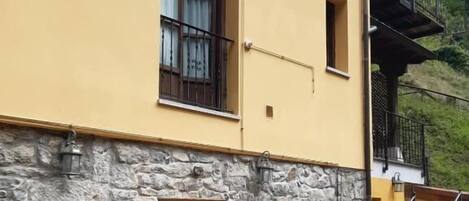 Un edificio a due piani con facciata in pietra e pareti gialle.