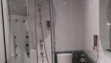 Une salle de bain moderne avec une douche à parois de verre, un lavabo blanc et un miroir.