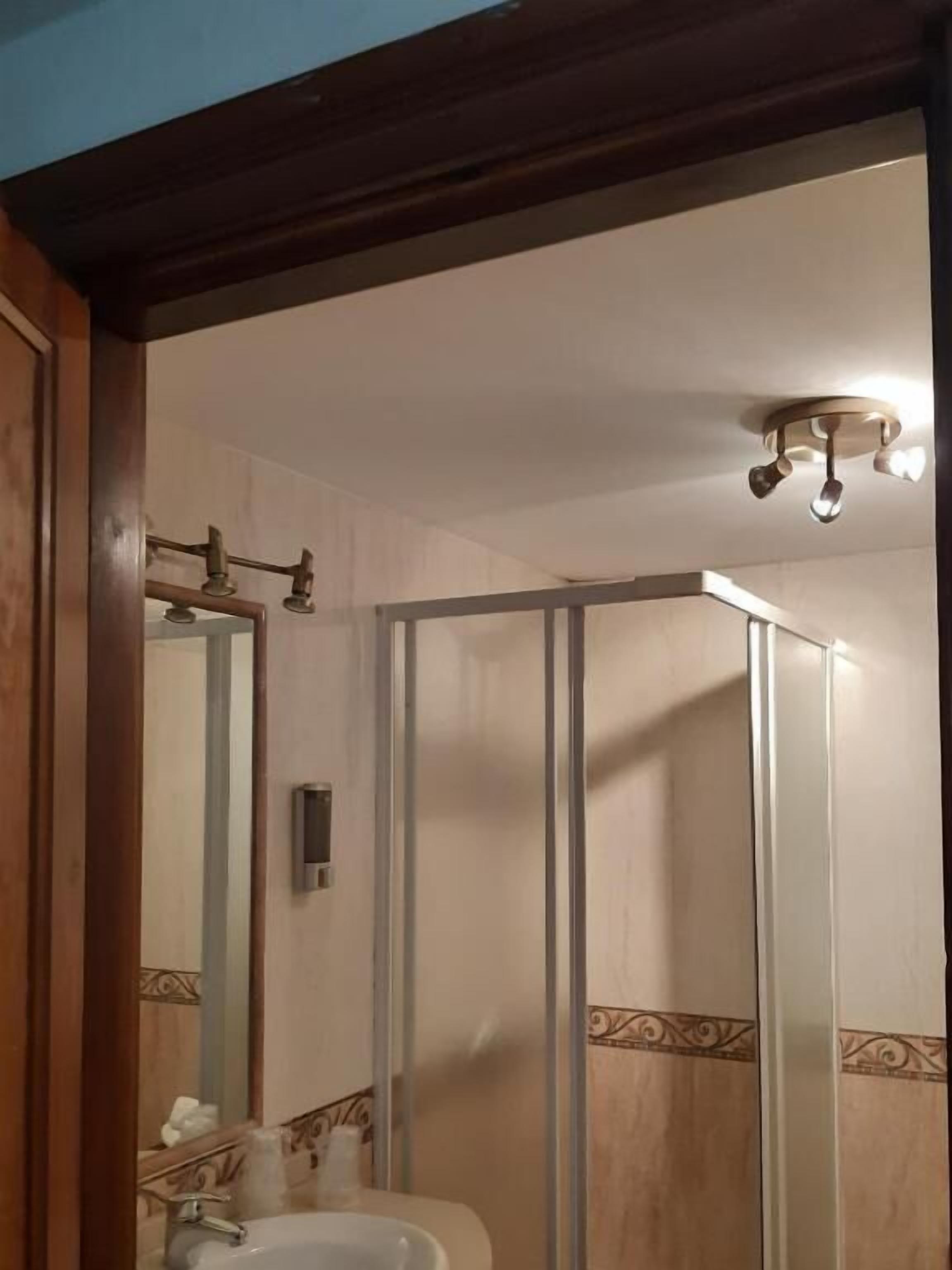 A bathroom with a shower, a sink, and a mirror.