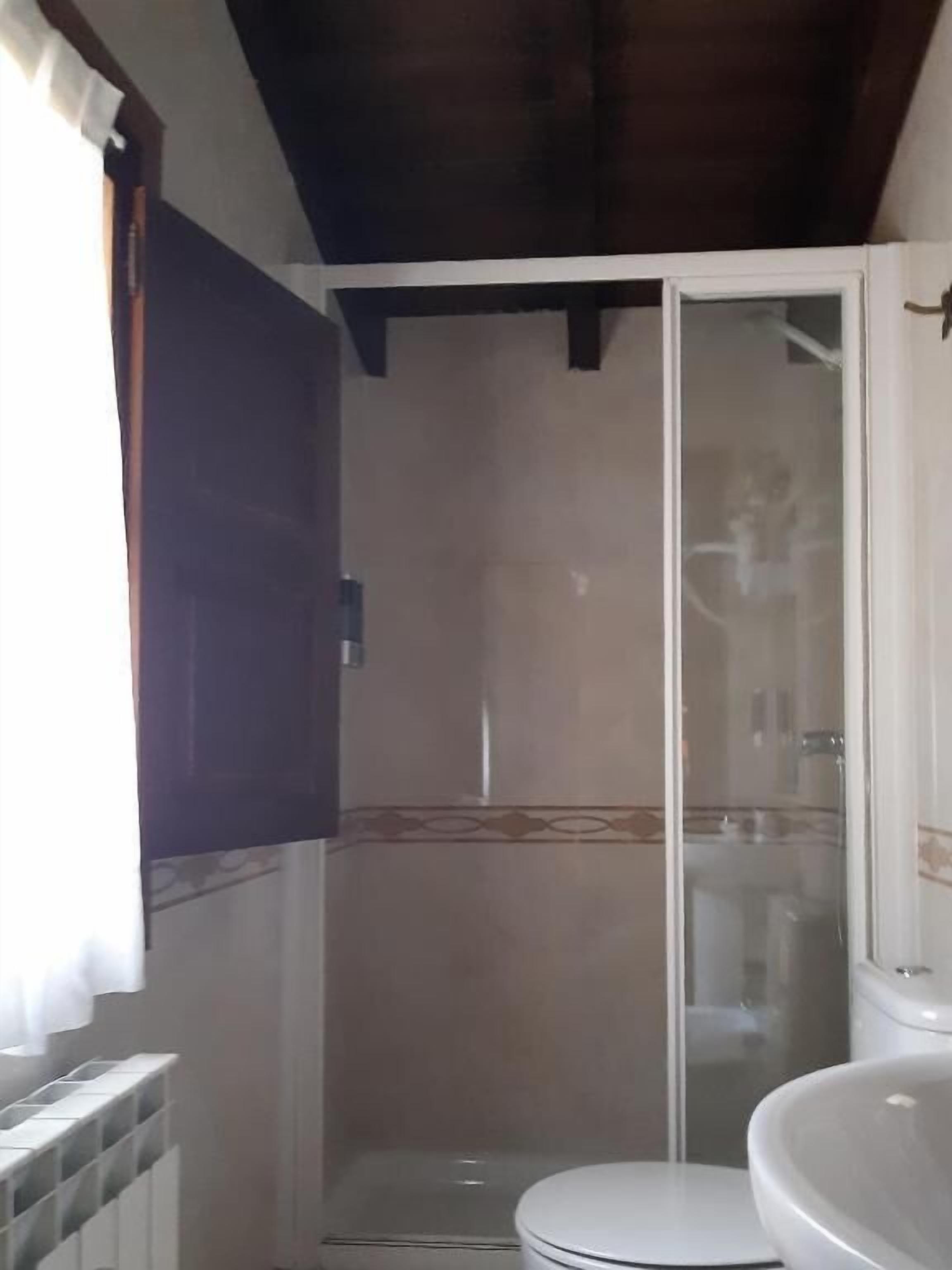 A bathroom with a shower, toilet, and sink.