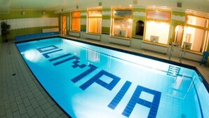 Una piscina con la palabra "PIRAMID" en el suelo, rodeada de ventanas con luces encendidas.