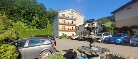 A building with a sign reading "OLIMPIA" and a fountain in the foreground.
