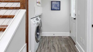 A laundry room with a washing machine, a dryer, and a ceiling fan. - Historic NoDa Mill House • Steps to Shops & Dining (Charlotte)
