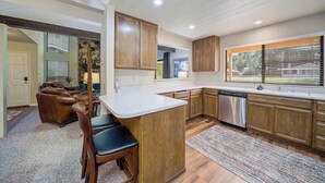 A modern kitchen with wooden cabinets, a white countertop, and a built-in dishwasher. - Caddyshack - 35 Aspen Circle (Plumas Eureka)
