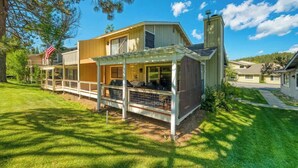 A two-story house with a covered patio, a chimney, and a flag. - Caddyshack - 35 Aspen Circle (Plumas Eureka)