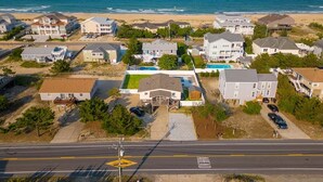 Vista aérea de una zona residencial costera con casas, una carretera y una playa.