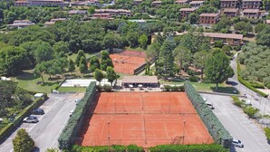 Un court de tennis entouré d’un parking et d’immeubles d’habitation.