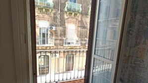 A balcony with a view of a building with balconies and a tiled floor. - Elizabeth House (Siracusa)