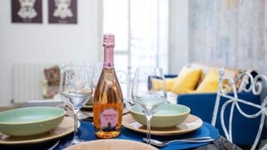 A dining table with a bottle of Prosecco, two wine glasses, and a bowl. - Elizabeth House (Siracusa)
