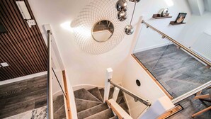 A modern staircase with a glass railing, a wooden handrail, and a carpeted floor. - Apartment 4 - The Crescent (York)
