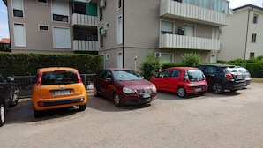 A parking lot with several cars parked in front of a building with balconies and air conditioning units. - Face River CLOSE   historic center  Well equipped can park free well front front (Padova)