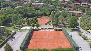 An aerial view of a tennis court surrounded by greenery and residential buildings. - Residenza CRB 38 by Wonderful Italy (Manerba del Garda)