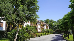 A row of multi-story residential buildings with balconies, surrounded by well-maintained greenery and a clear sky. - Residenza CRB 38 by Wonderful Italy (Manerba del Garda)