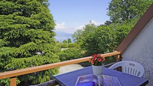 A balcony with a table, a chair, and a potted plant. - Residenza CRB 38 by Wonderful Italy (Manerba del Garda)