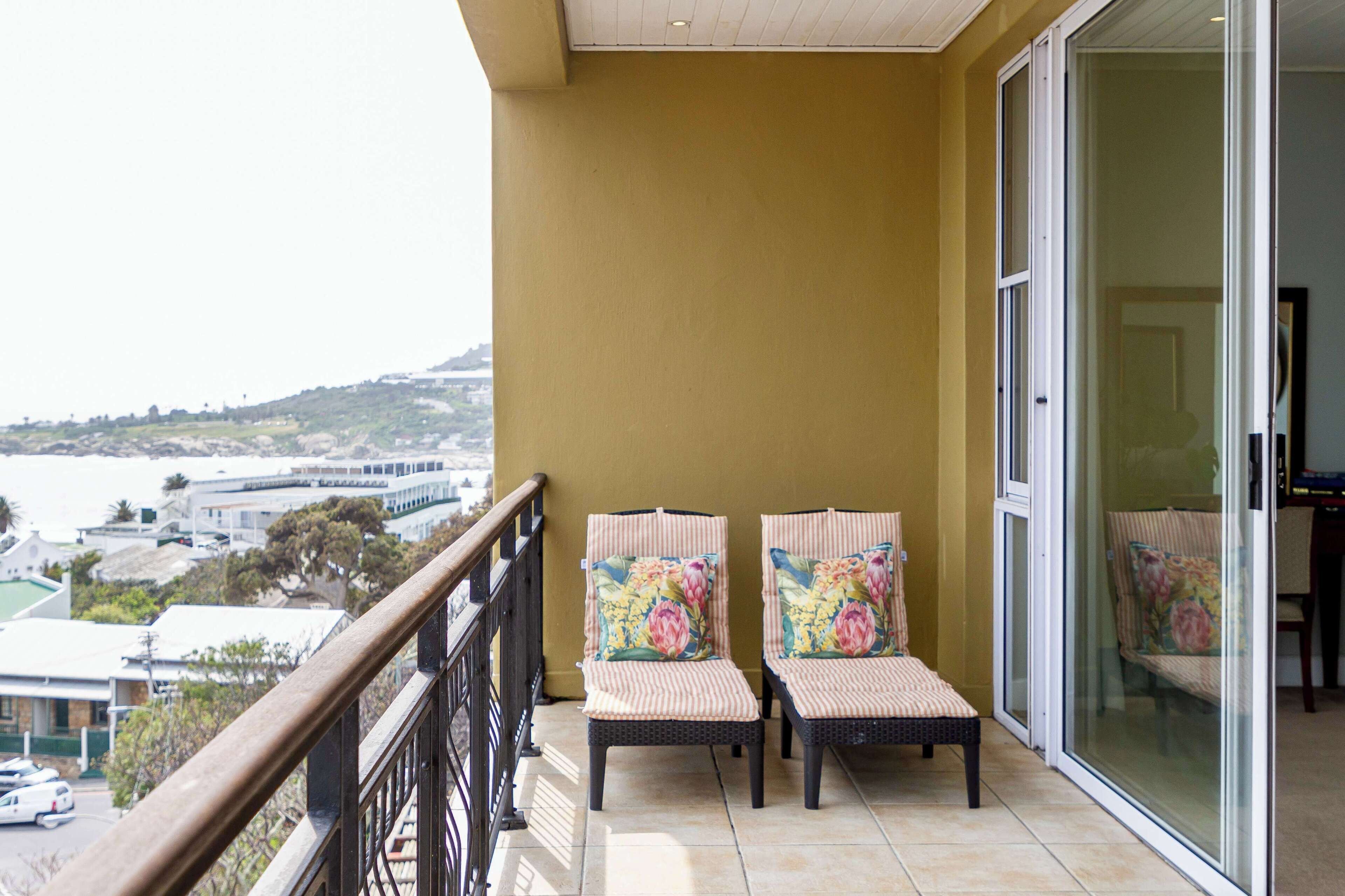 Ein Balkon mit zwei Korbstühlen und einer Glastür.