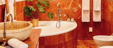 Un baño con una bañera independiente, un lavabo y un inodoro.