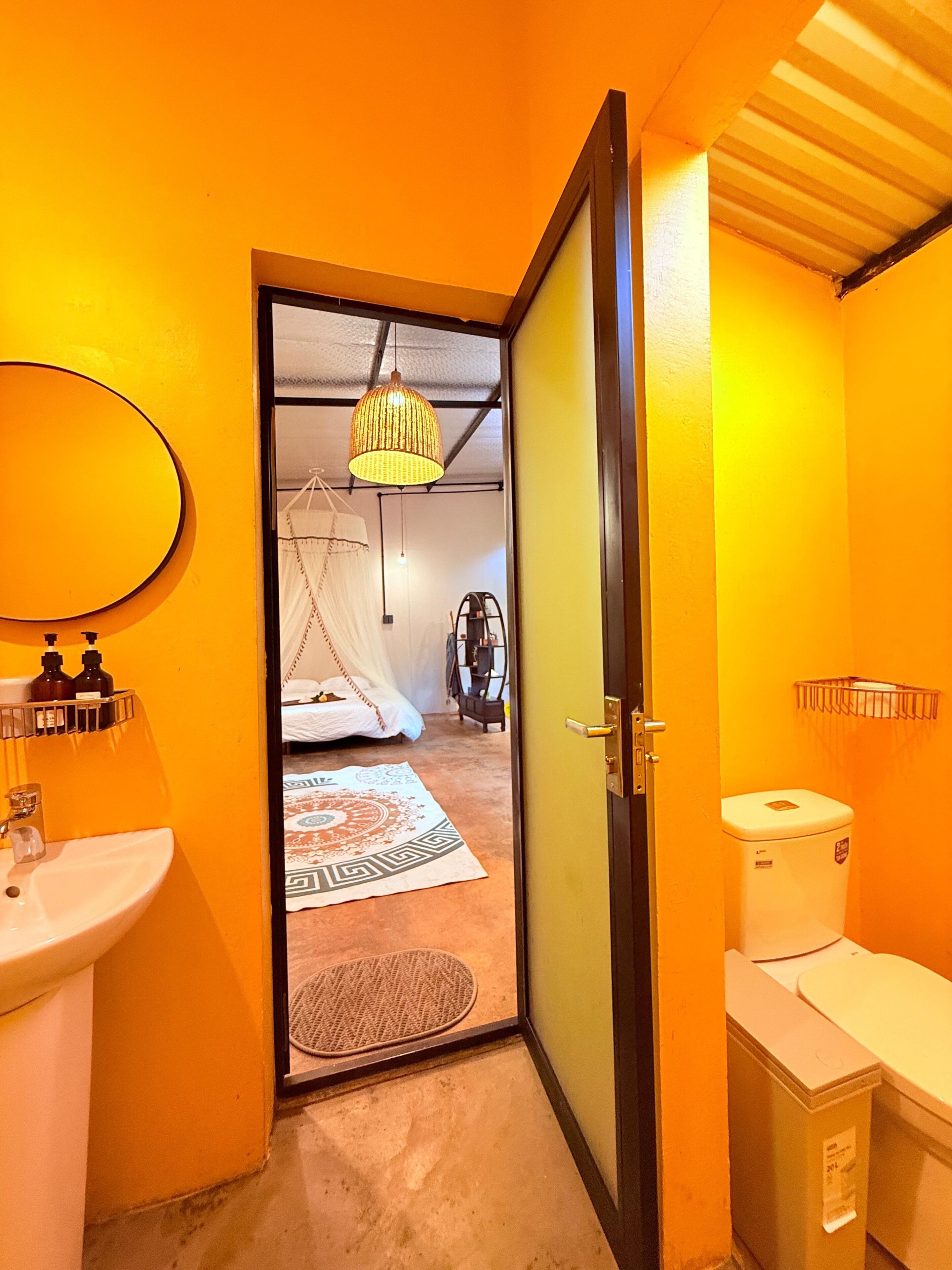 Un baño con lavamanos, inodoro y espejo.