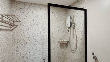 Een moderne badkamer met een douche met glazen wand, een toilet en een handdoekhouder.