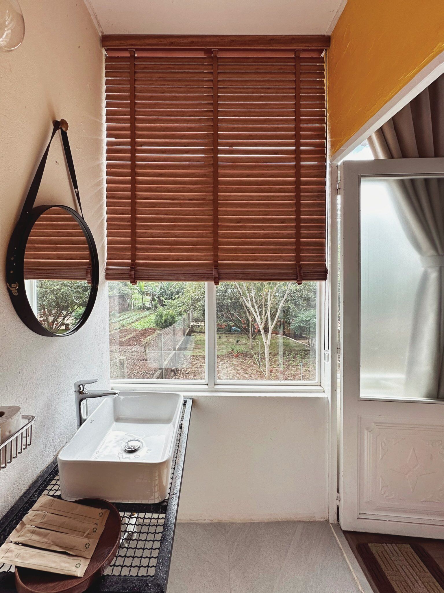 A bathroom with a window, a sink, and a mirror.