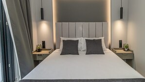 Une chambre d’hôtel moderne dotée d’un grand lit, de deux tables de chevet et d’une tête de lit avec éclairage intégré.