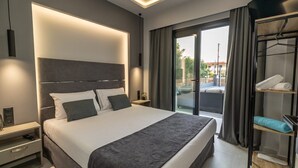 Une chambre d’hôtel moderne dotée d’un grand lit, d’une table de chevet, d’une armoire et d’un balcon avec des rideaux.
