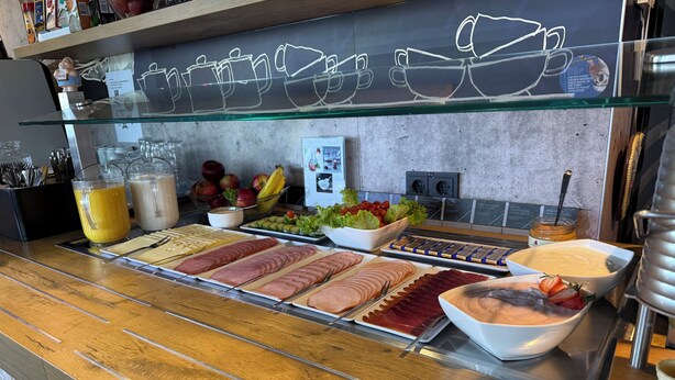 Un buffet proposant une variété de plats, une vitrine réfrigérée et un espace dédié au café.