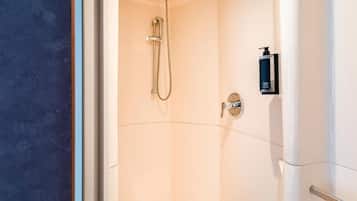 Une salle de bain moderne équipée d’une douche, d’un distributeur de savon et d’un sèche-mains.