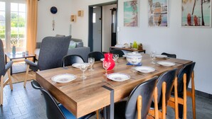 Comedor con una mesa de madera dispuesta para seis personas, rodeada de sillas.