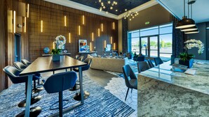 Un hall d’hôtel moderne avec un comptoir d’accueil en bois, un espace salon et de grandes fenêtres offrant une vue panoramique.