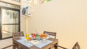 Une table à manger avec une machine à café, des pâtisseries et des fruits.