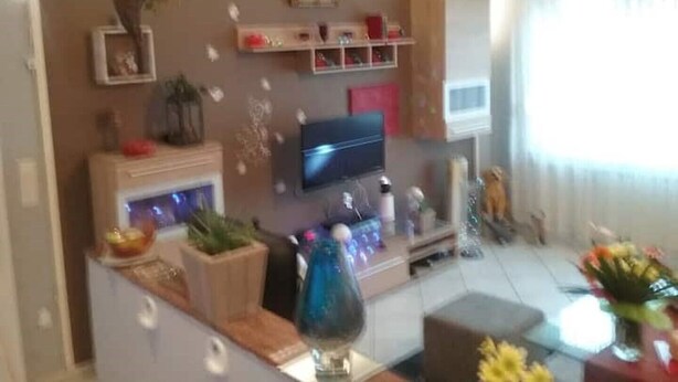 A living room with a flat-screen TV, wooden shelves, and a vase with flowers. - Komfortable Wohnung Zentral zur City(5km) Eifel(10km)
Belgien(2km)Holland(12km) (Aachen)