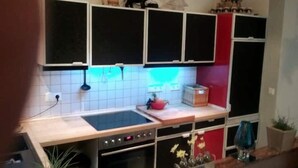 A kitchen with a central island, a microwave, and a toaster. There are cabinets above the island and a small plant on the countertop. - Komfortable Wohnung Zentral zur City(5km) Eifel(10km)
Belgien(2km)Holland(12km) (Aachen)