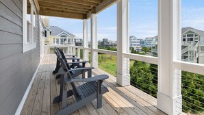 En inglasad veranda med träbänkar och utsikt över de omkringliggande husen.