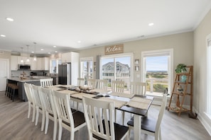 Una cocina amplia con comedor, ventanas grandes y vista a una casa.