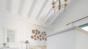 Een slaapkamer met een bed, een dressoir, een nachtkastje en een wanddecoratie.
