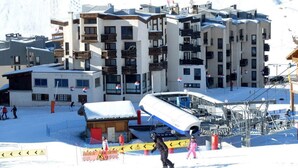 A ski resort with multi-story buildings, a ski lift, and a small lodge. - 100m from resort center, 4th floor, balcony, tv, ski locker, 24m², Tignes (Tignes)