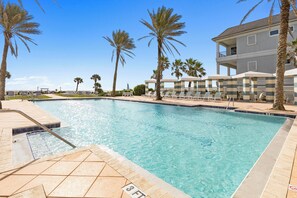 A swimming pool with a 3 FT depth marker, surrounded by palm trees and lounge chairs.