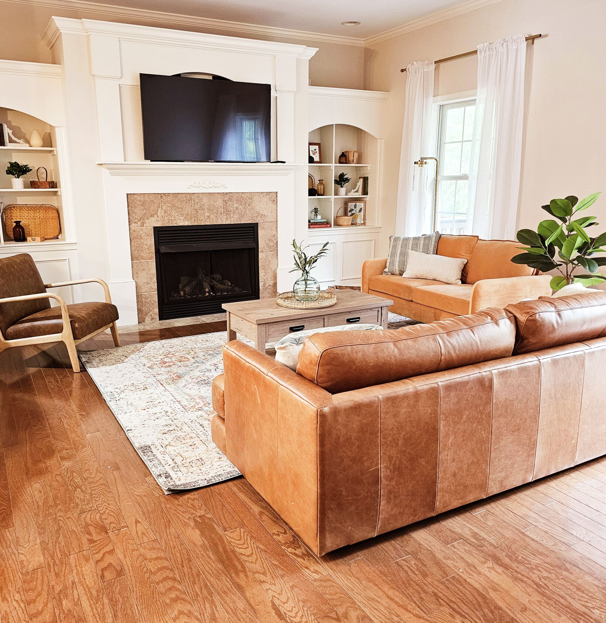 A living room with a fireplace, a sofa, a coffee table, and a TV.
