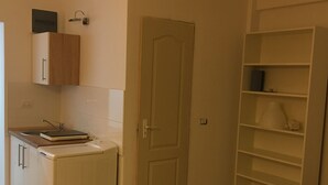 Eine kleine Küche mit Waschmaschine, einer Tür und einer eingebauten Regallösung.